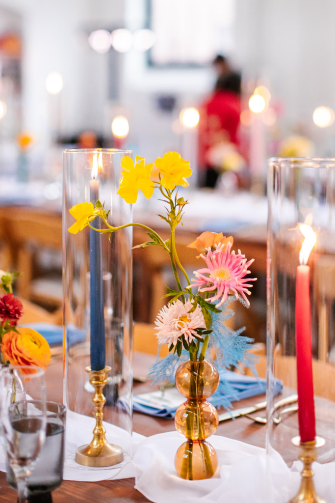 Colorful and eclectic wedding flower centerpiece with candles