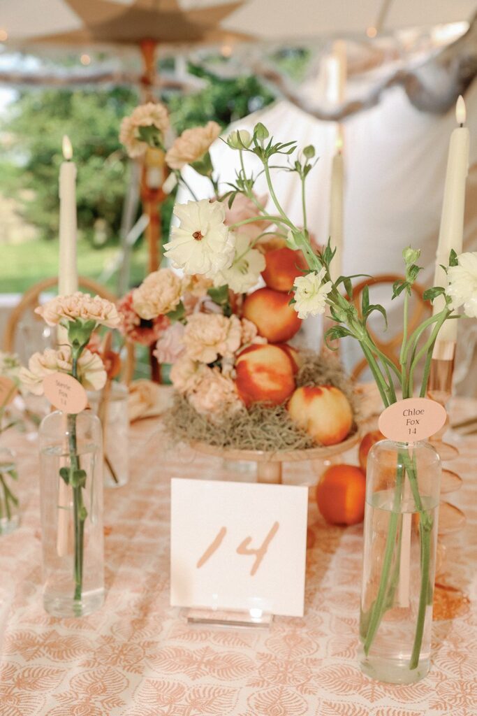 An eclectic, color-blocked tablescape of monochromatic coral-tone fruit and flowers