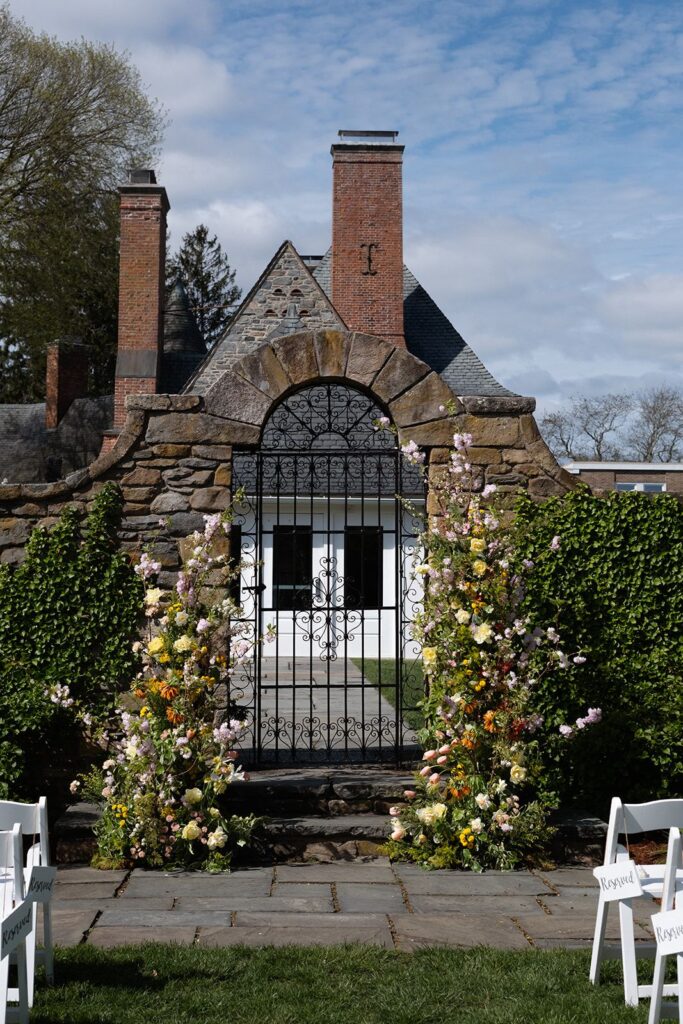 Elaborate castle-like stonework and a deconstructed arch of spring flowers.