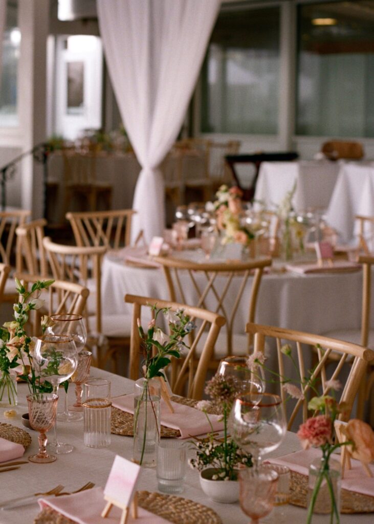 A mix of ikebana and bud vase arrangements as centerpieces at a wedding reception.