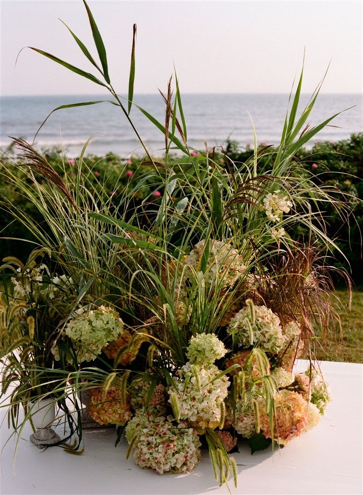 A closeup of one side of a wedding ceremony floral installation made from hydrangeas and local grasses.