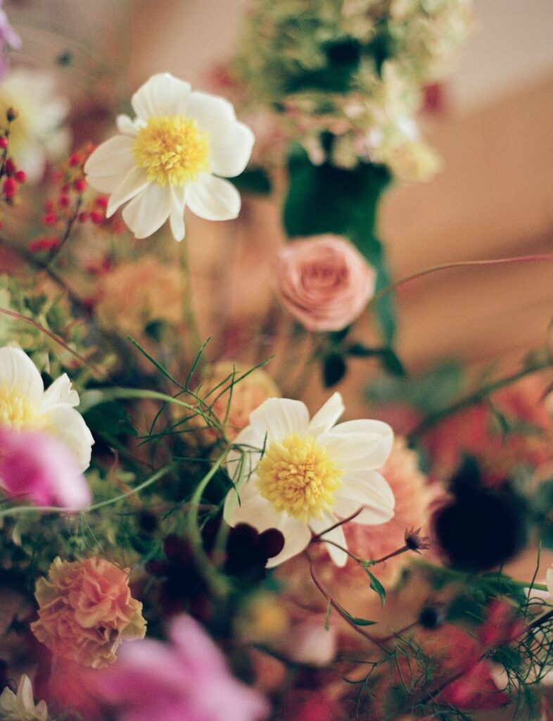 A floral arrangement featuring roses, carnations, and claire de lune peonies.