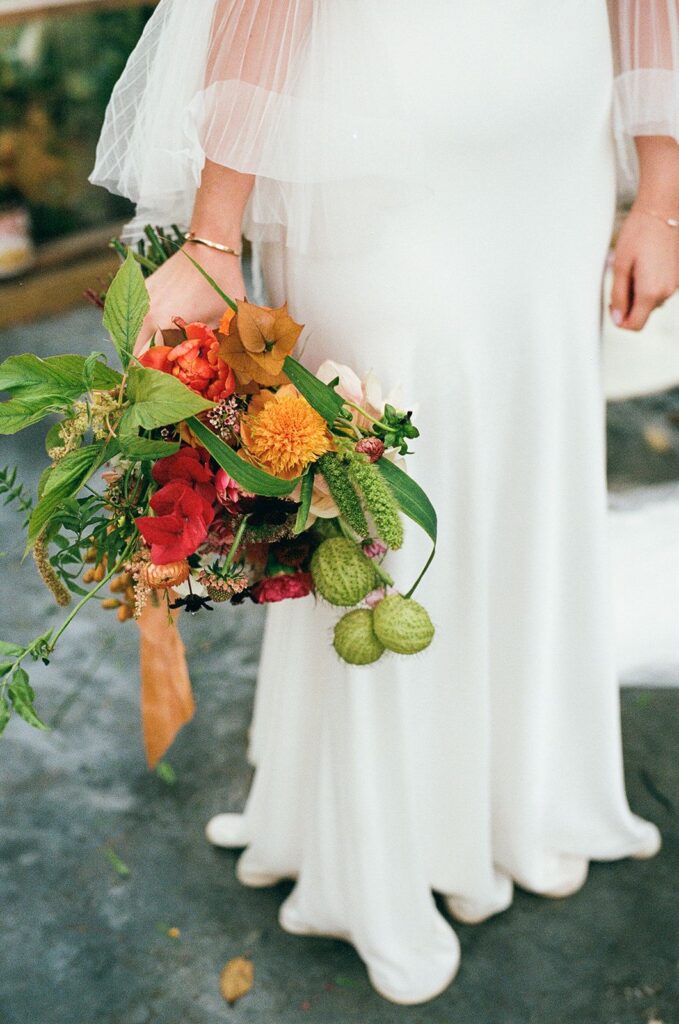 A bridal bouquet featuring milkweed seed pods, dates, scabiosa, and more.