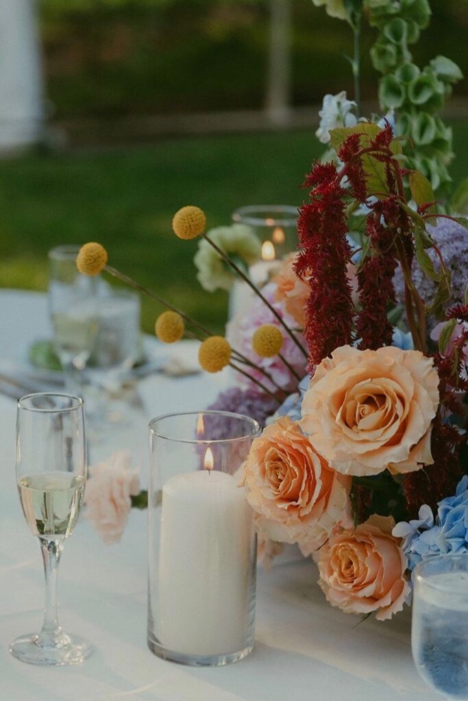 A wedding centerpiece featuring roses, anthurium, bells of Ireland, billy balls, and more.