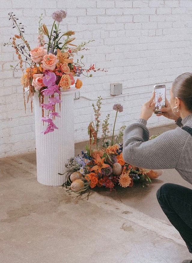 A wedding ceremony install featuring orchids, roses, allium, lilies, protea, and more.
