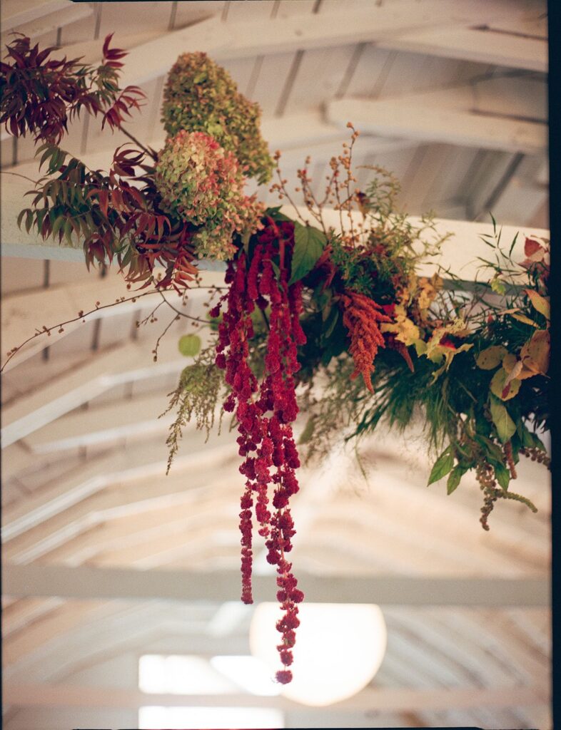 A hanging fall floral install containing foliage, hydrangeas, amaranthus, and more.